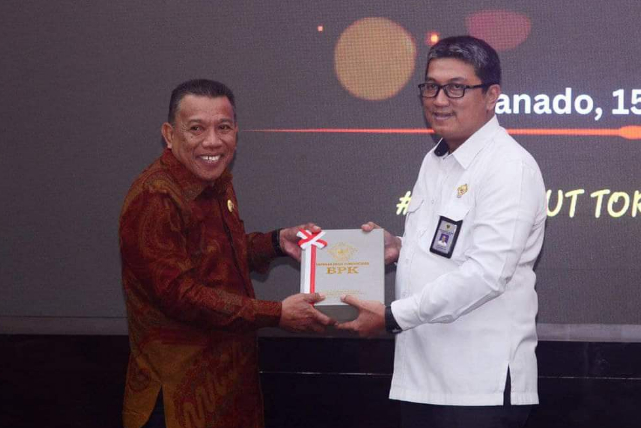 Depri Pontoh saat menerima penghargaan Opini WTP atas LKPD Pemkab Bolmut dari BPK RI perwakilan Sulawesi Utara