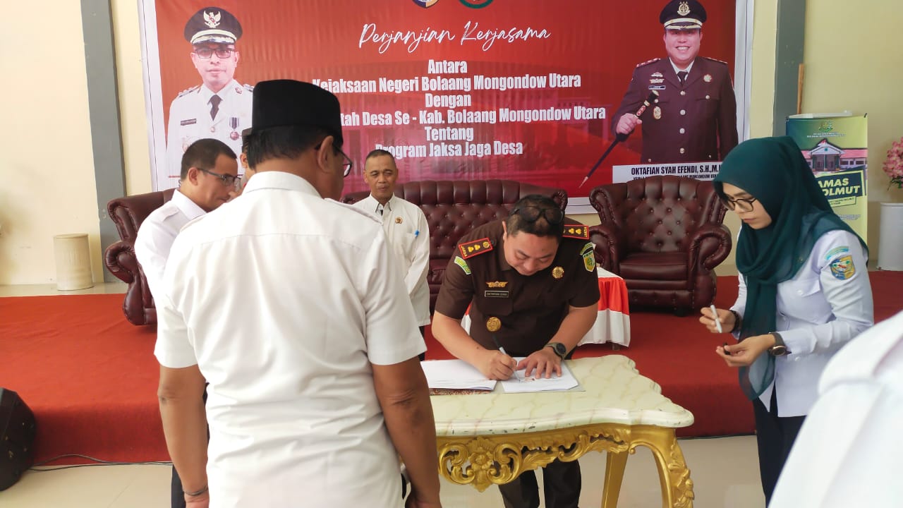 Kajari Bolmut Oktafian Syah Effendi saat menandatangani perjanjian Kerjasama Jaksa Jaga Desa 