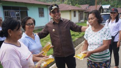 Sirajudin Lasena saat memberi bantuan sembako berupa minyak goreng ke warga