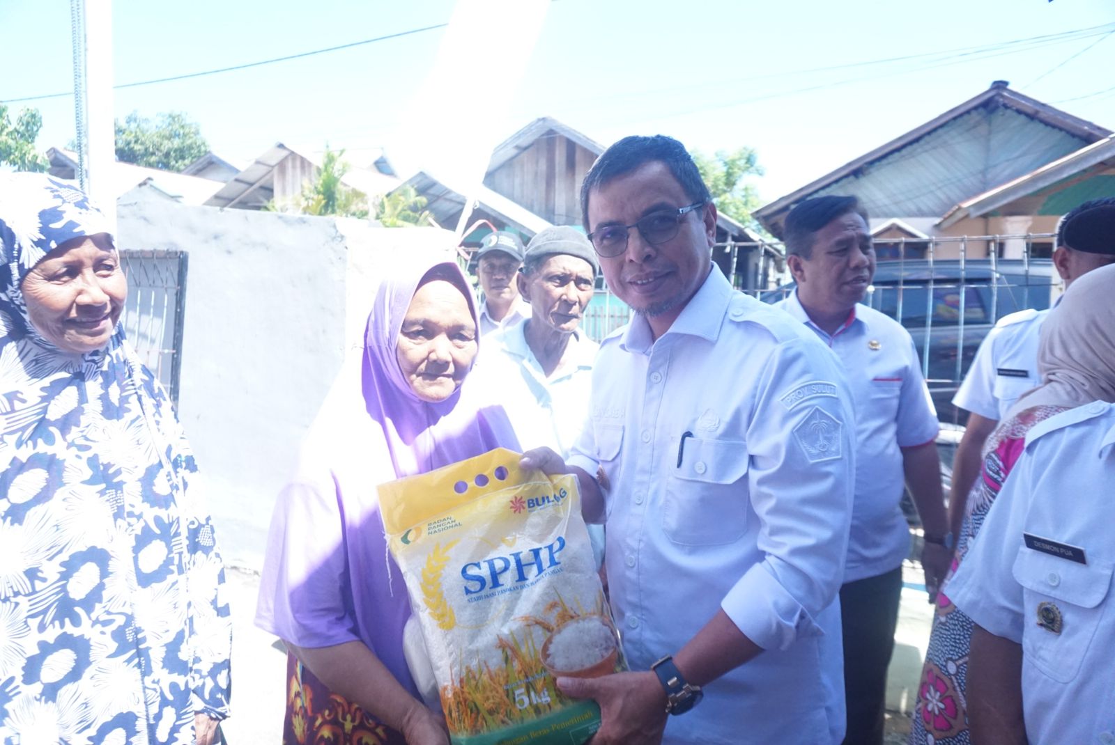 Pj Bupati Bolmut Sirajudin Lasena saat menyerahkan beras ke warga yang merupakan langkah Pemkab Bolmut di Gerakan Pangan Murah